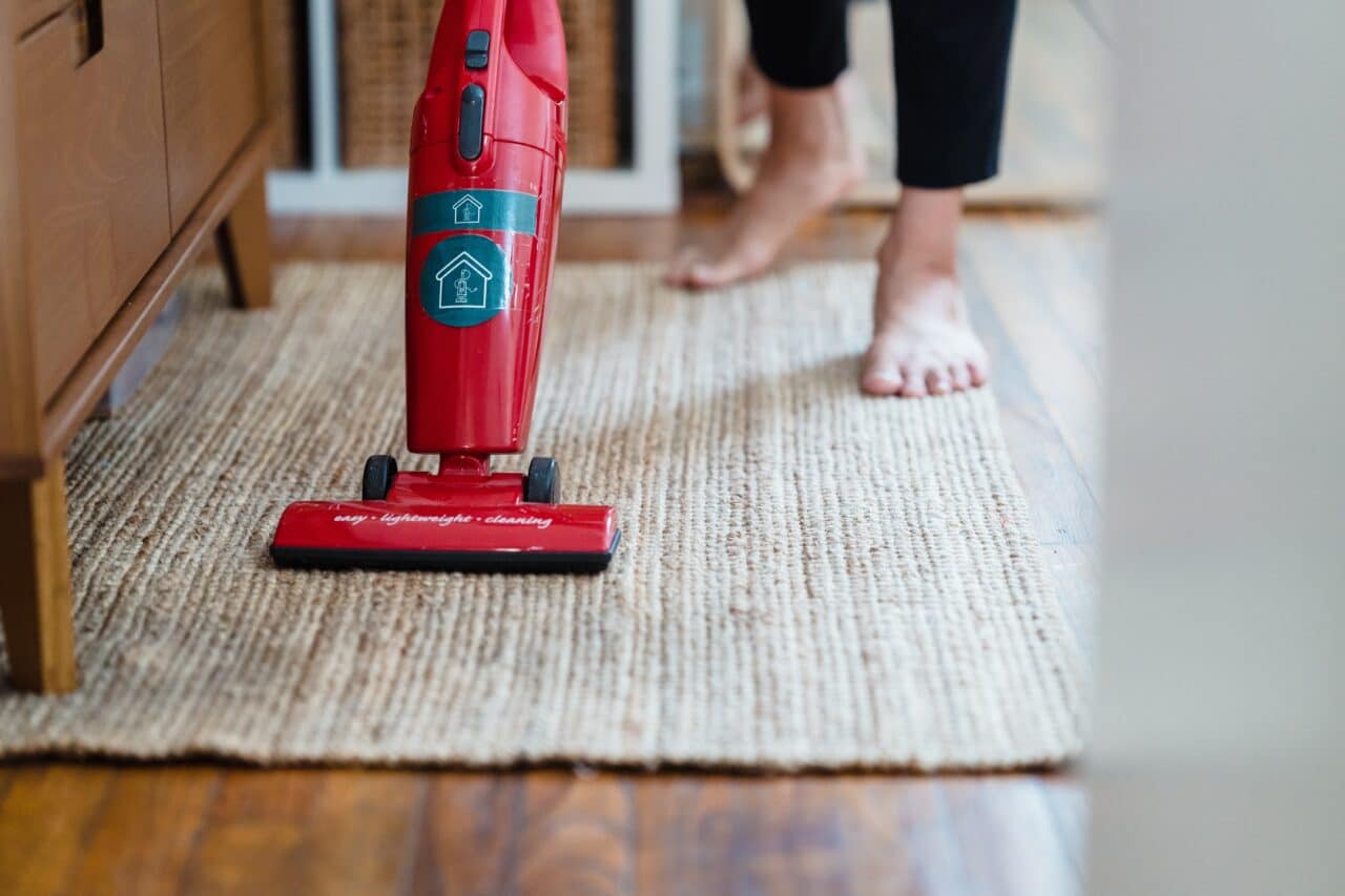 Close-up of a woman vacuuming her home.