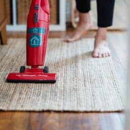 Close-up of a woman vacuuming her home.