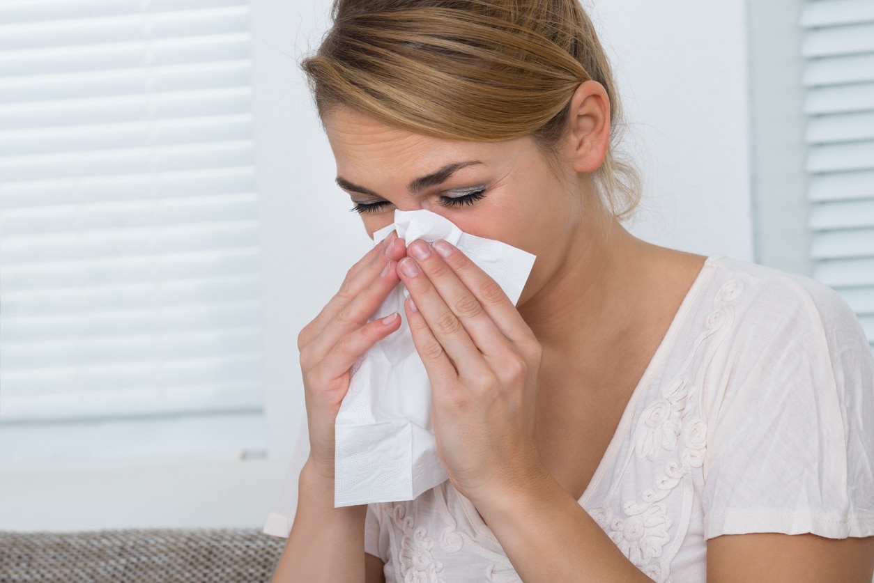 Woman blowing her nose.