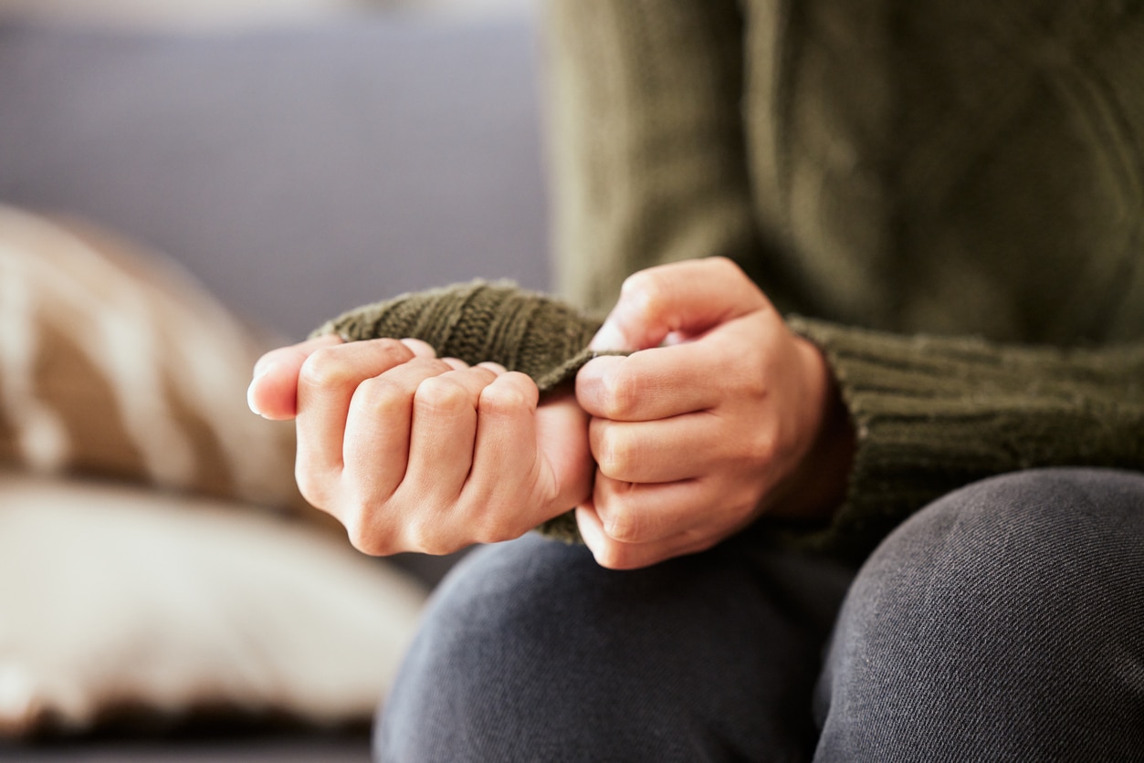 Anxious woman clasping her hands.