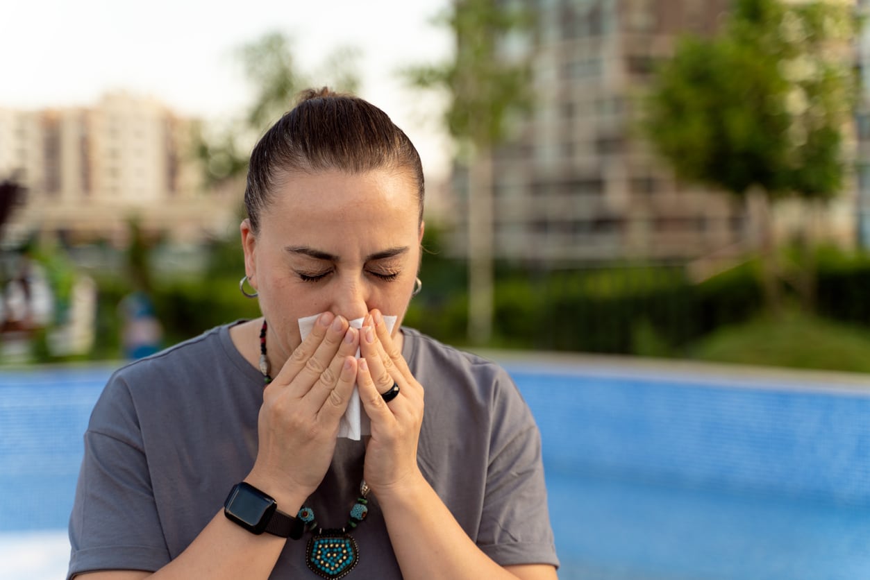 Woman blows nose in city park