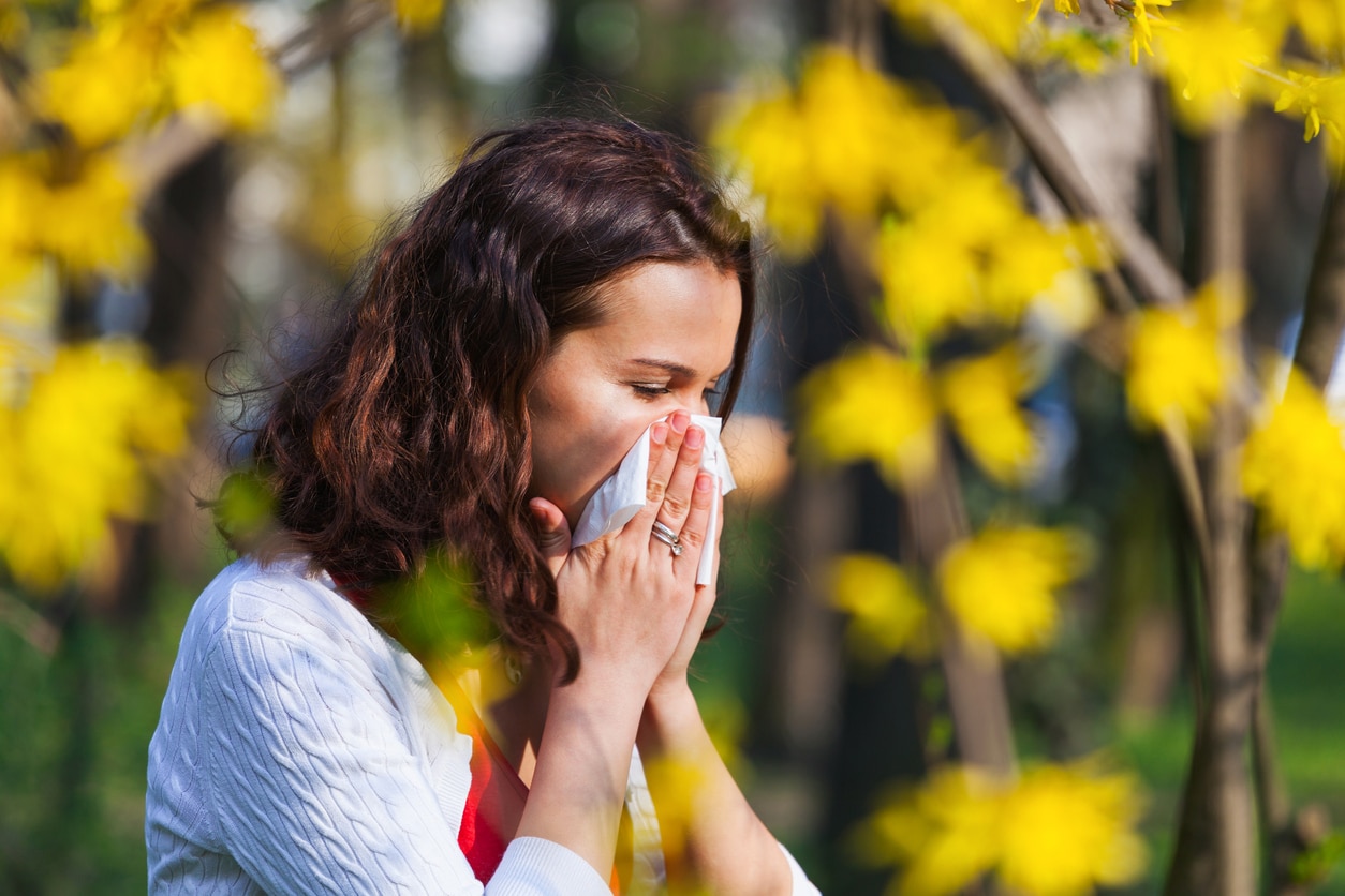 Woman blows nose in park