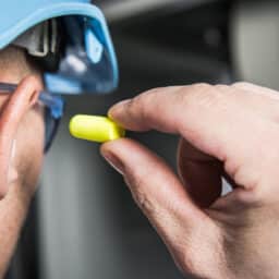 Worker places earplug