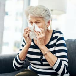 Senior woman blowing her nose