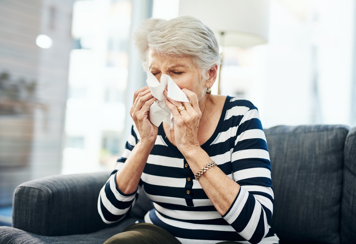 Senior woman blowing her nose