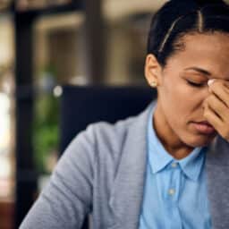 Woman with nose pain holding her nose