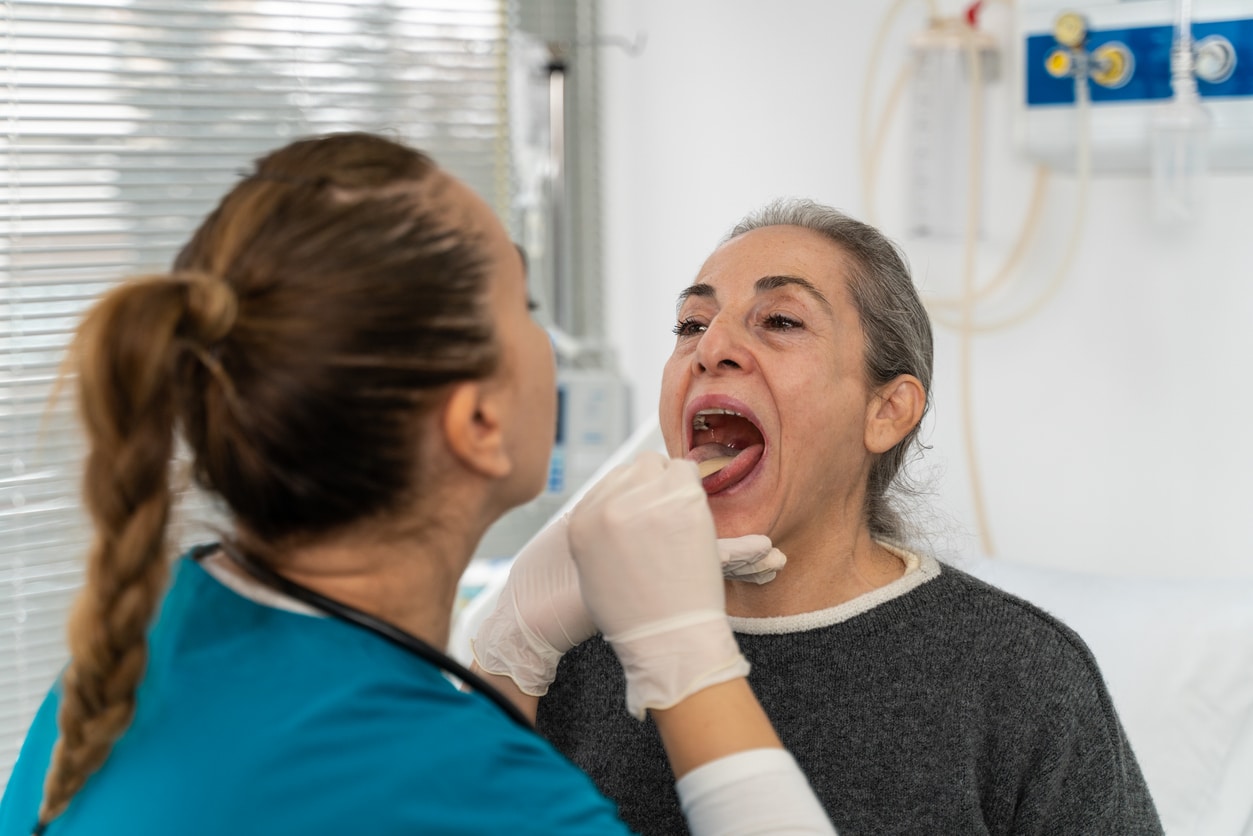 ENT examining a senior woman's throat
