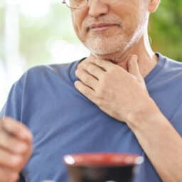 Man holding his uncomfortable throat