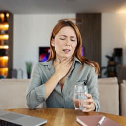 Woman feeling discomfort from a sore throat