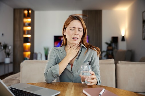Woman feeling discomfort from a sore throat